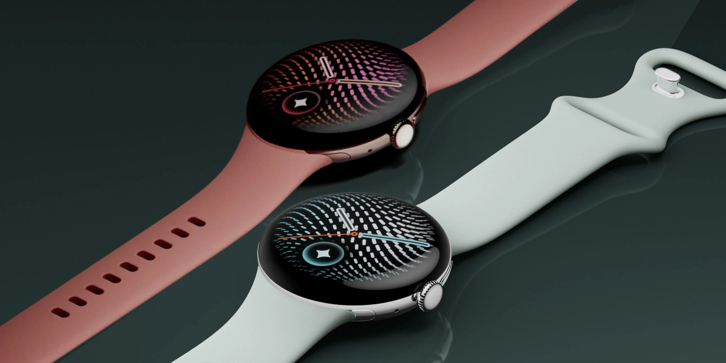 An overhead, angled view of two Google Pixel Watch 5 devices, featuring the Active Bands in Canyon and Fog, laying flat against a dark background.