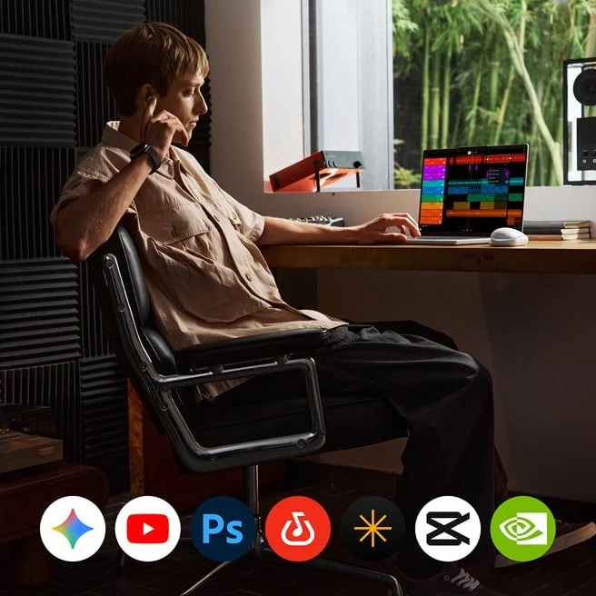 A person uses a Lenovo Googlebook while sitting at their desk, with app icons displayed along the bottom.