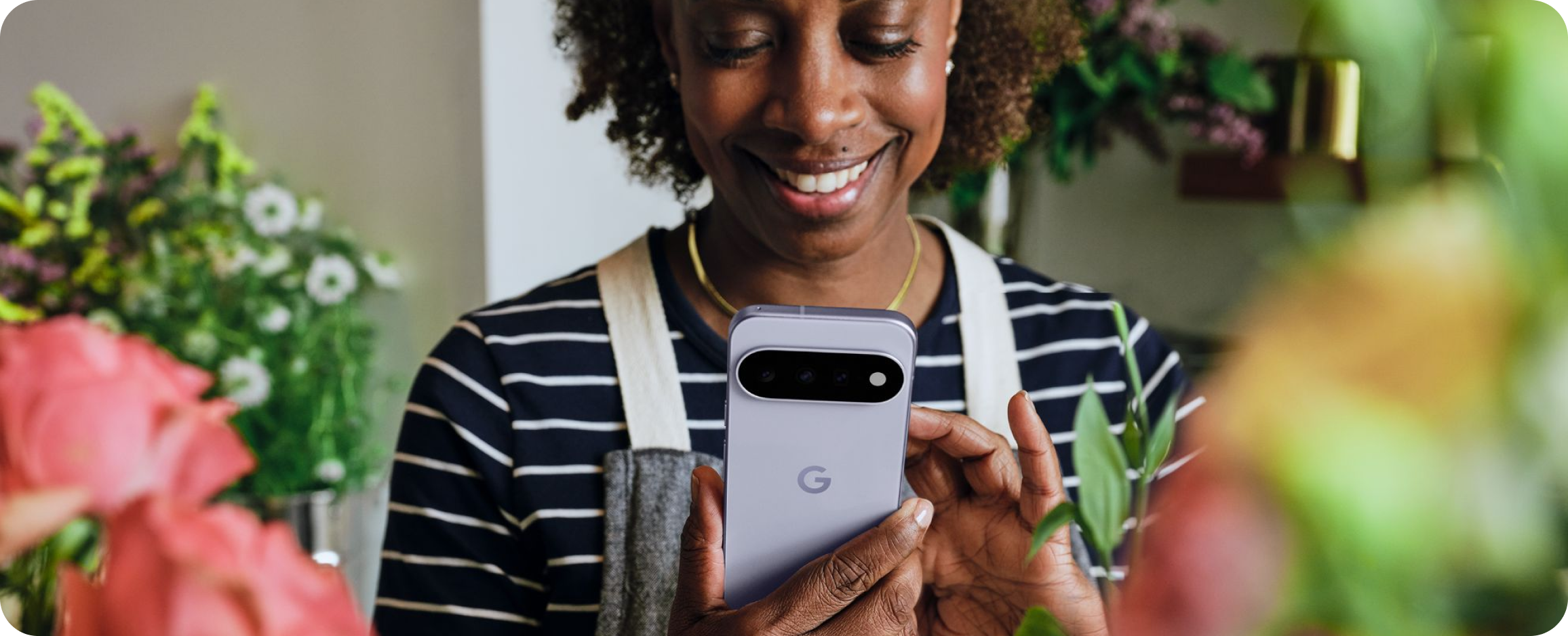 A flower shop owner interacts with Gemini on her Google Pixel 11 phone.