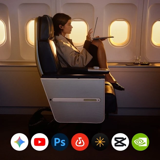 A person working in a premium airplane cabin with Google AI app icons displayed.