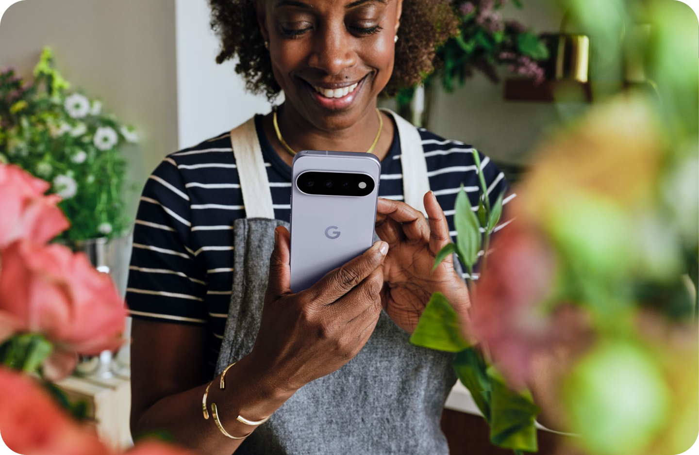 A flower shop owner interacts with Gemini on her Google Pixel 11 phone.